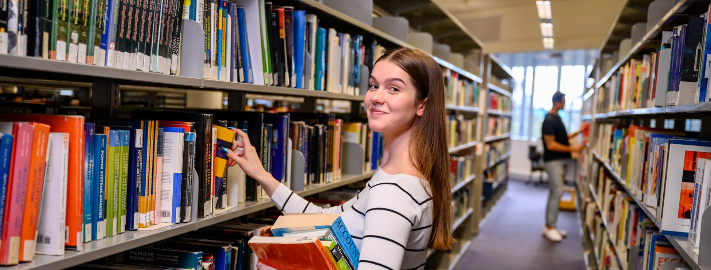 Female holding books in library